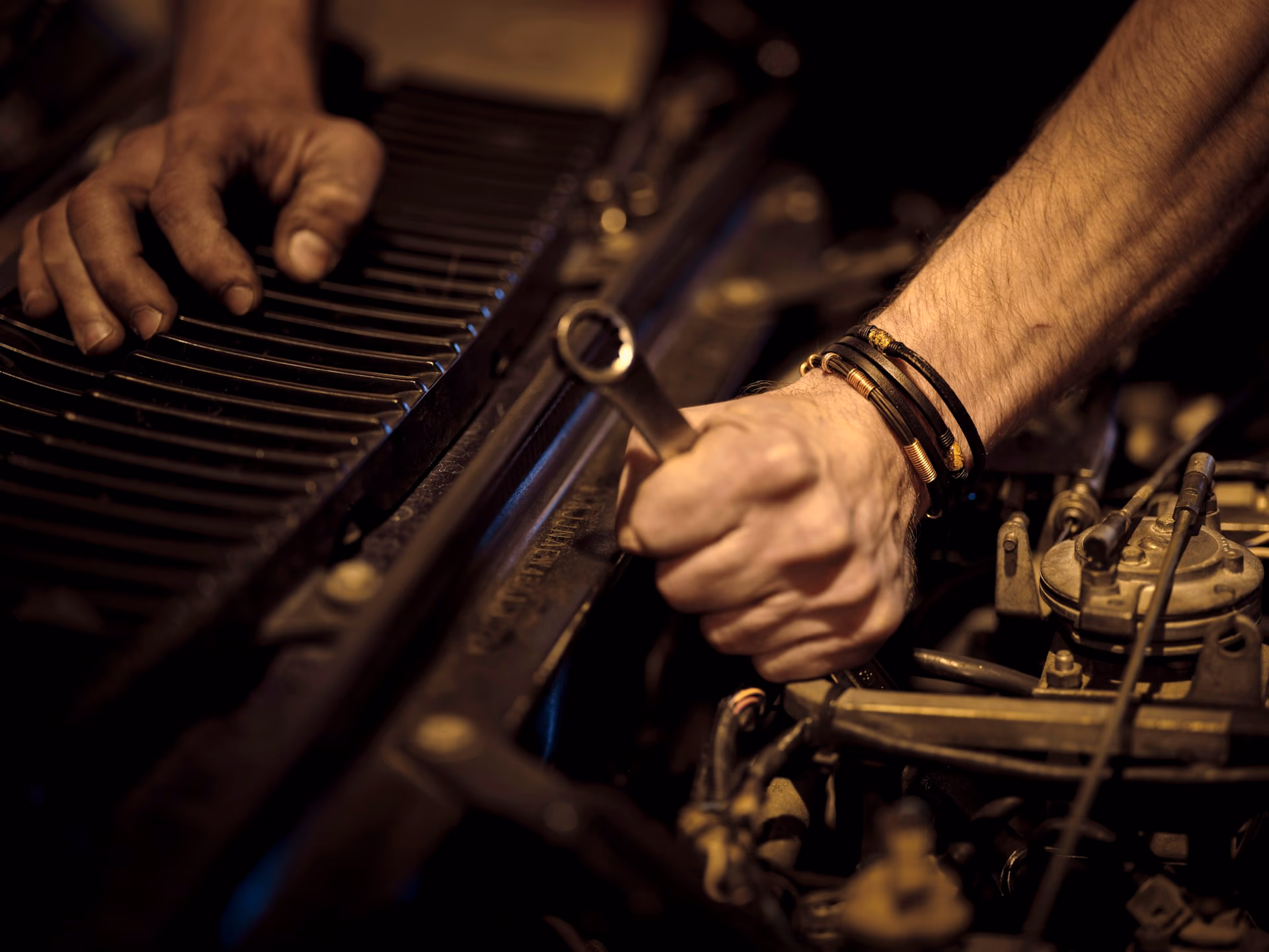 Mecánico revisando el motor de un vehículo con herramienta profesional